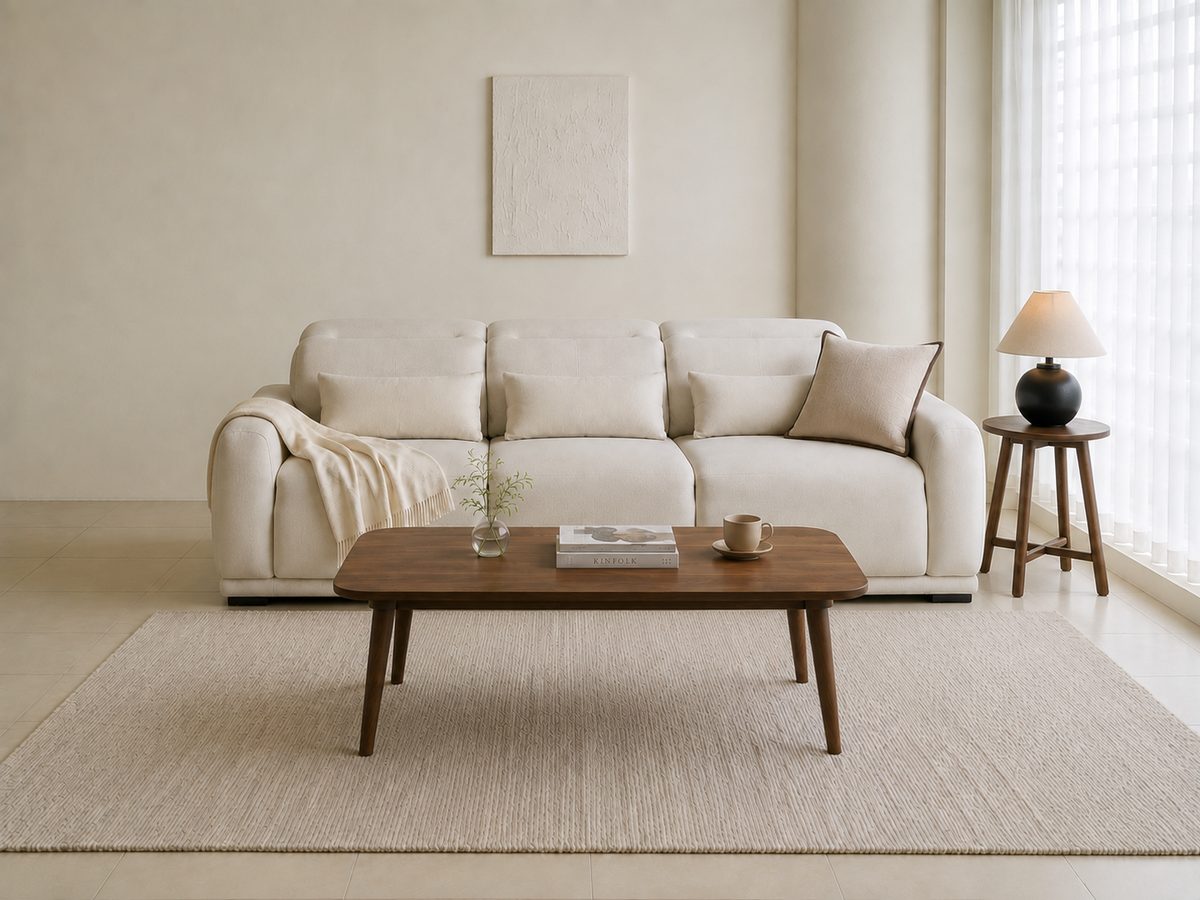 The same living room with the furniture repositioned — the sofa and coffee table sit at different angles, while the wall, floor and window are unchanged