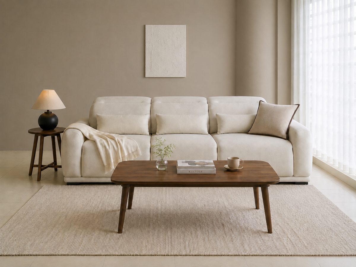 The same living room with the walls changed from off-white to a warm greige; the sofa, tables, rug and floor are unchanged